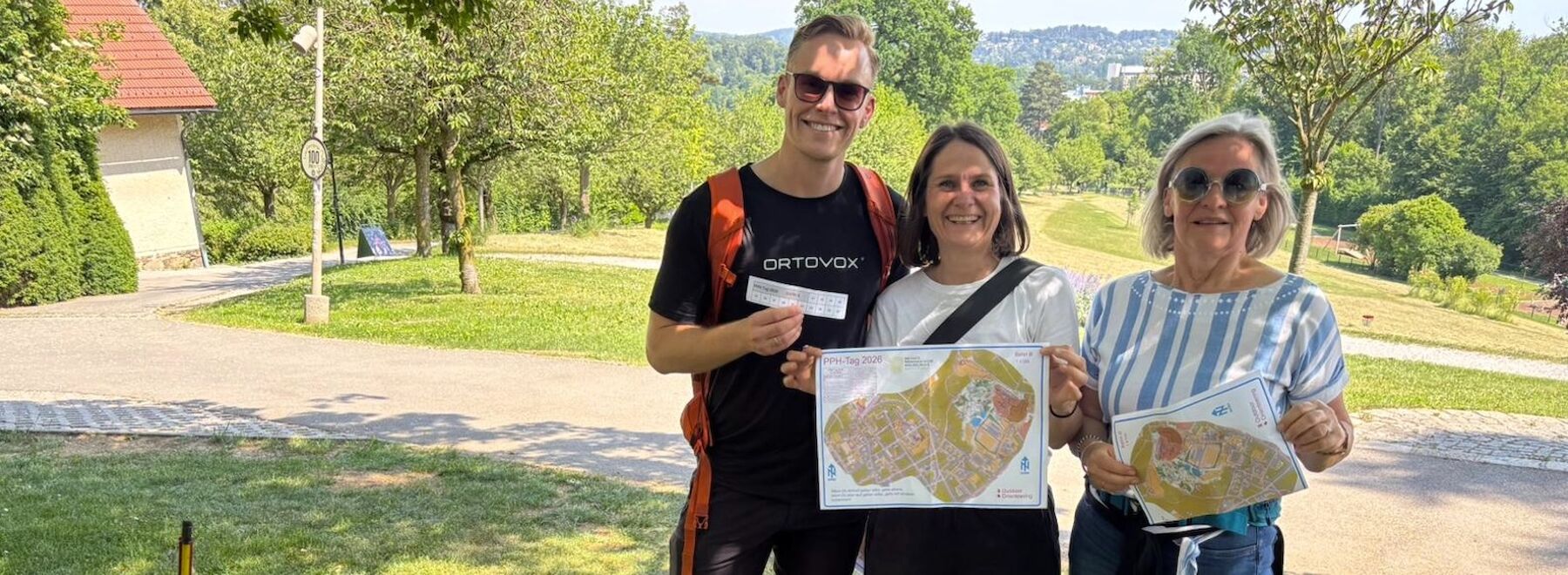drei Lehrende auf der Wiese vor dem Café Rosenhain