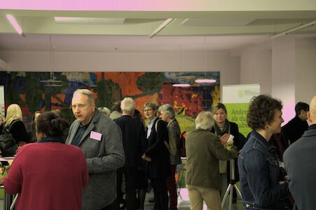 Menschen, die bei einer Networking-Veranstaltung oder einem Empfang in geschlossenen Räumen Kontakte knüpfen und sich unterhalten.