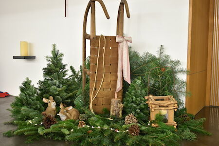 Vintage-Schlitten mit Band, Tannenzweigen, Hirschfiguren und Tannenzapfen.