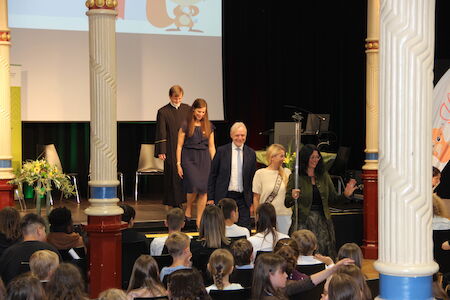 Bei einer Veranstaltung verlassen Menschen die Bühne, davor sitzt ein Publikum.