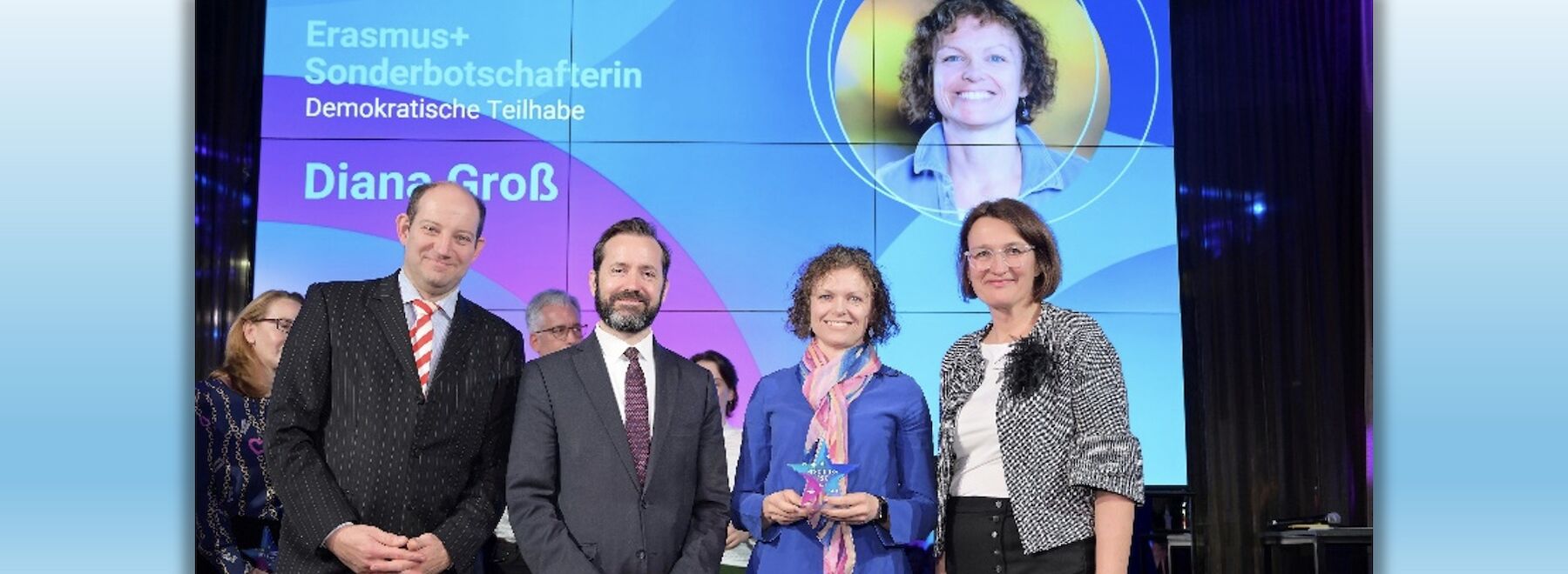 Diana Groß erhält auf einer Bühne die Auszeichnung.