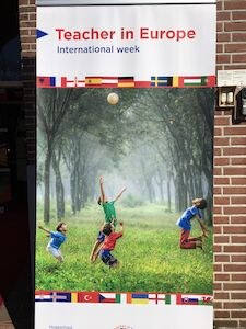 Banner für die internationale Lehrerwoche in Europa mit Fußball spielenden Kindern.