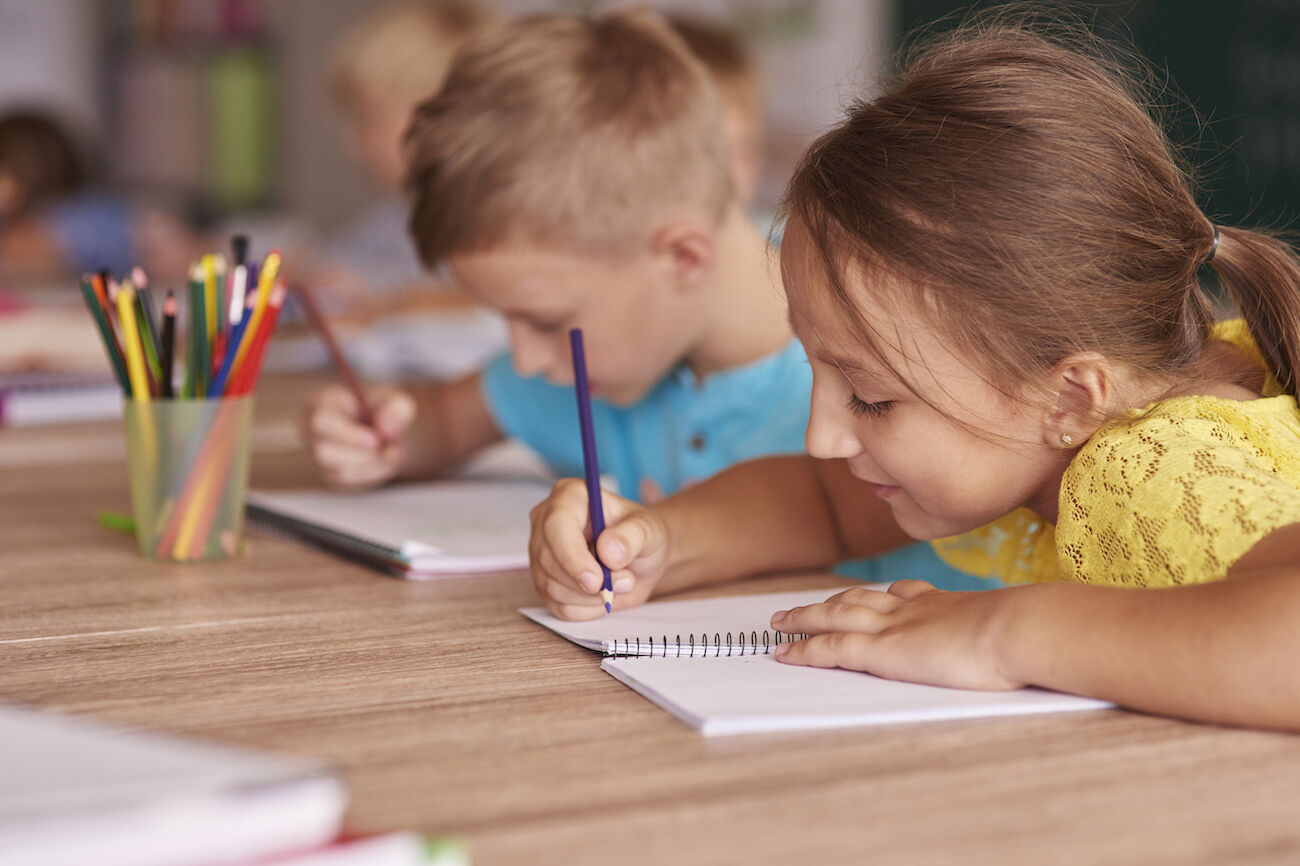 Zwei Kinder schreiben an einem Tisch