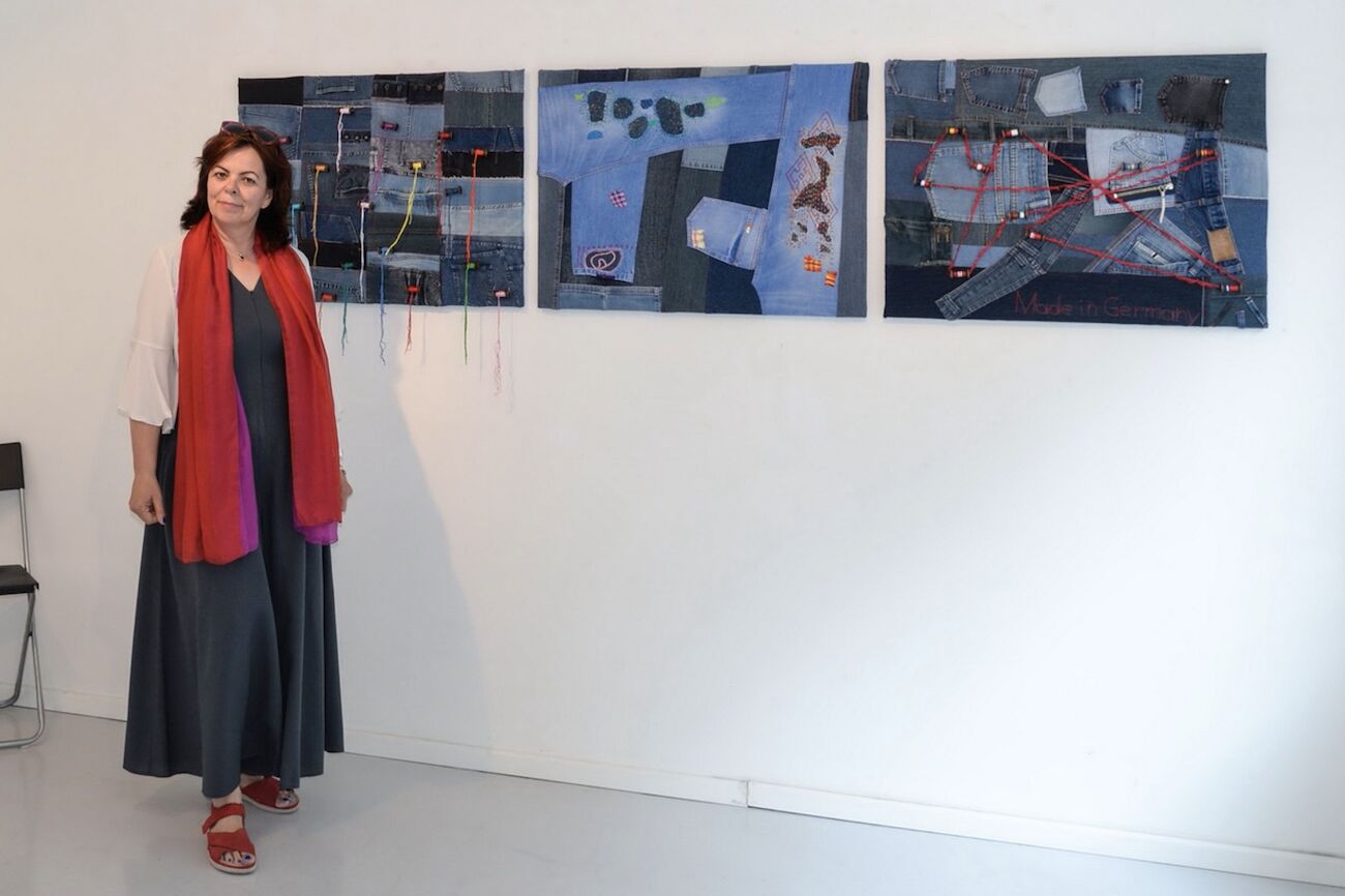Christine Guttmann vor drei Bildern ihrer Ausstellung