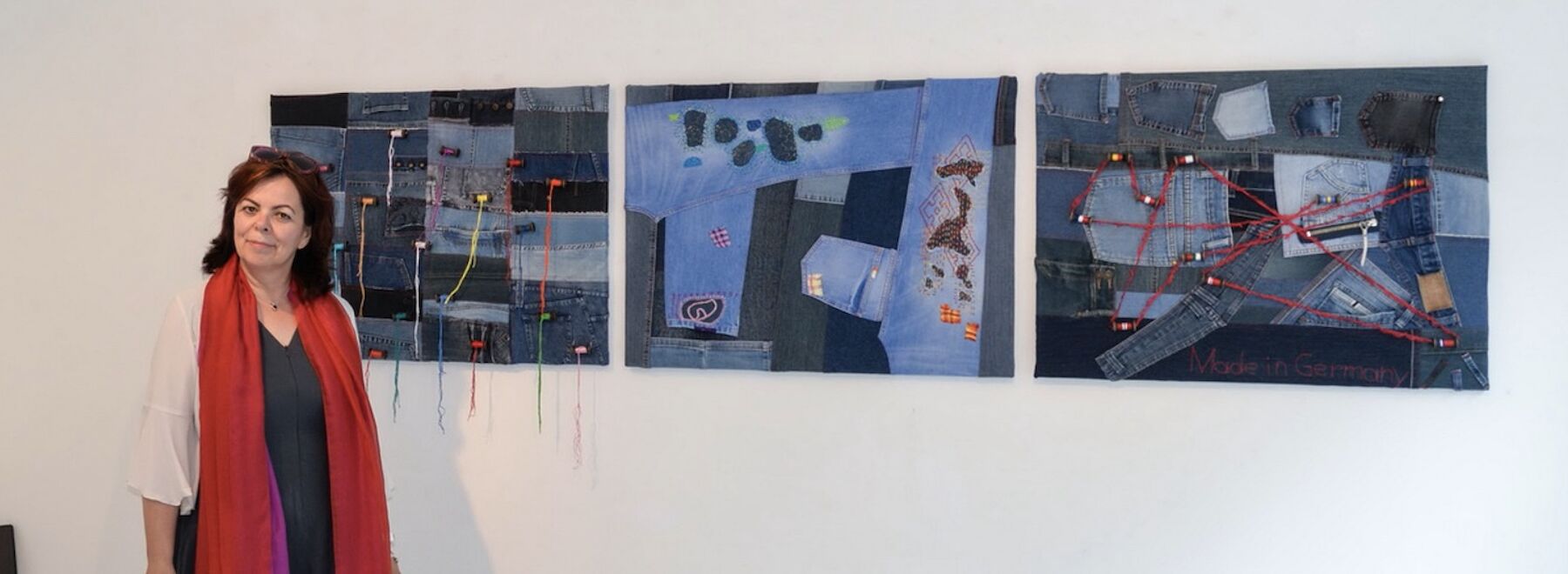 Christine Guttmann vor drei Bildern ihrer Ausstellung