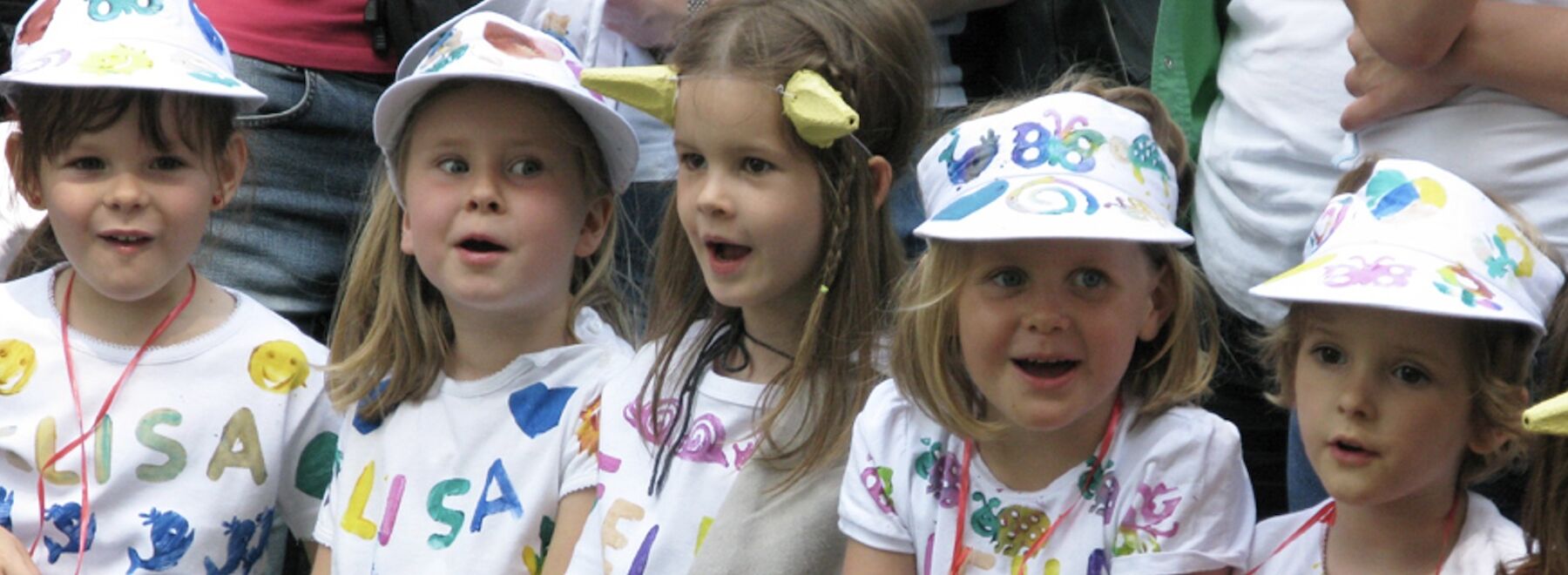 Fünf Kindergartenkinder sitzen in einer Reihe
