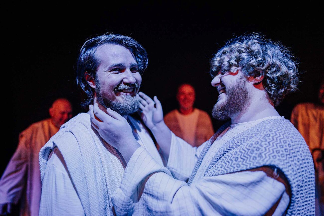 Zwei verkleidete Männer auf der Theaterbühne lachend